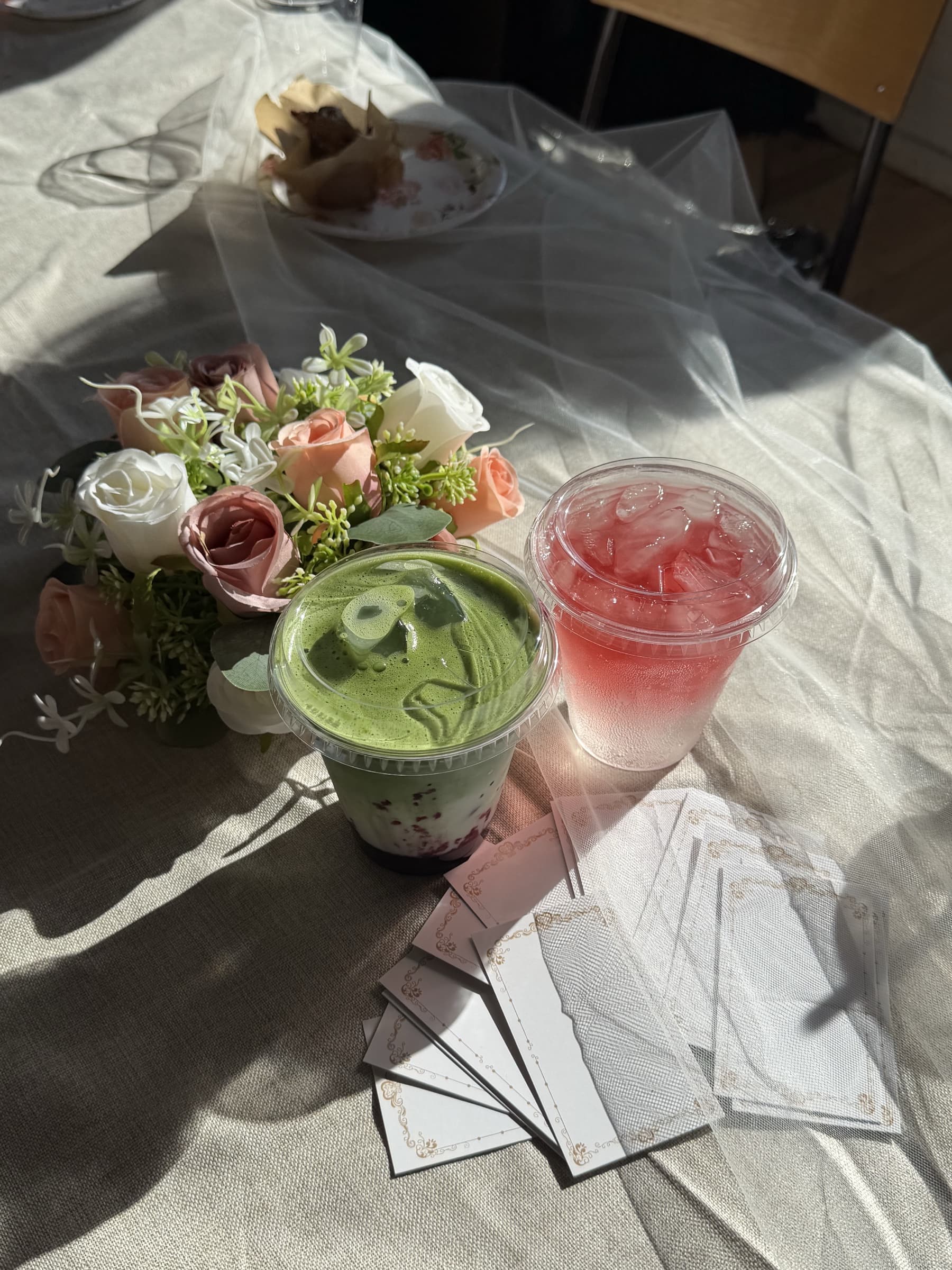 Matcha and fruit tea served beside flowers at an event